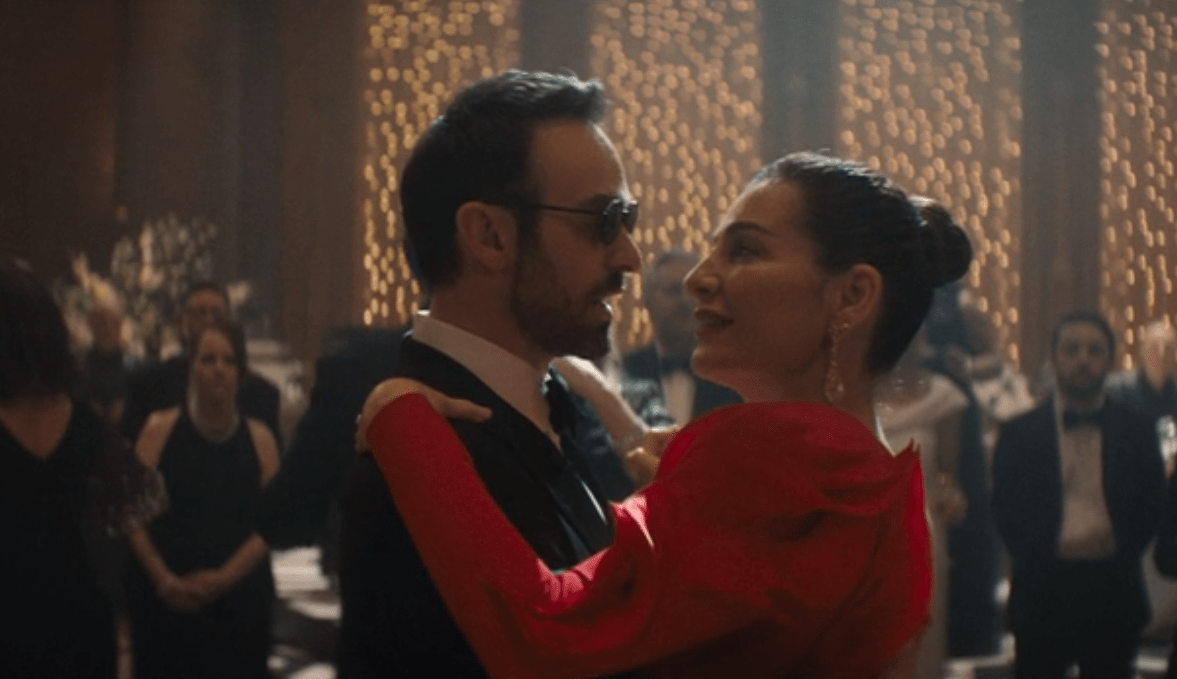 Matt Murdock dancing with Vanessa Fisk. He wears a suit and she wears a red dress. They are at some fancy gala. From Daredevil: Born Again